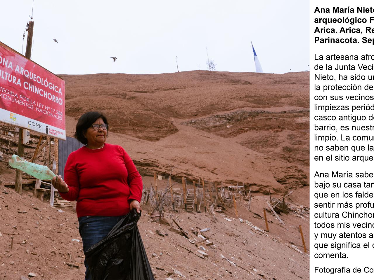 Ana María Nieto Farías posando con una botella desechada en la mano en el sitio arqueológico Faldeo Norte del Morro de Arica